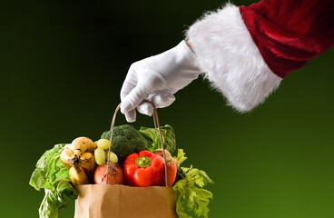 Santa's hand holding a bag full of food isolated background