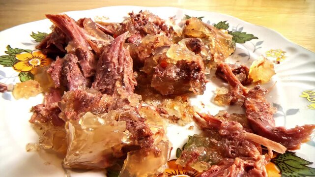 Close-up of cold meat jelly dish with shredded pork and gelatinous texture
