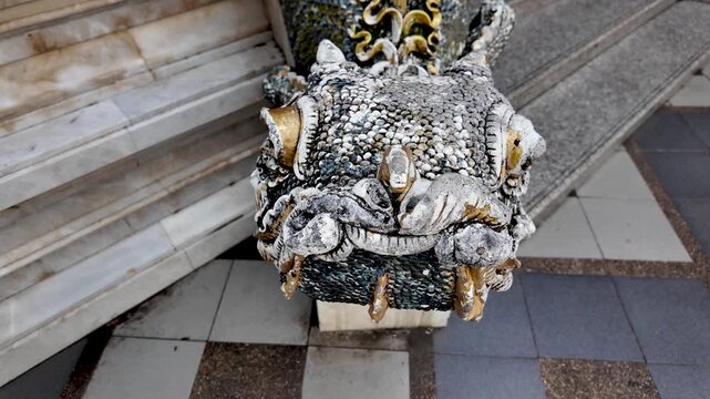 Ornate naga dragon stone sculpture guarding a Thai temple, intricate details and sacred guardian motif.