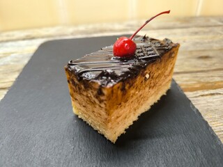 Chocolate cake with cherries on a granite board