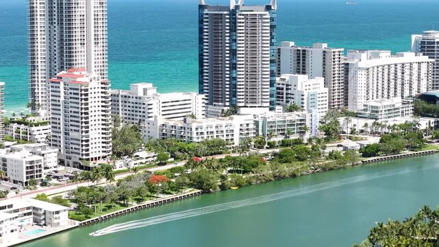 Miami Beach, Florida USA, Drone Shot of Boat in Indian Creek and Beachfront Towers and Buildings