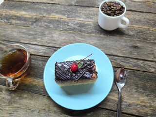 Chocolate cake with cherries lies on a white plate