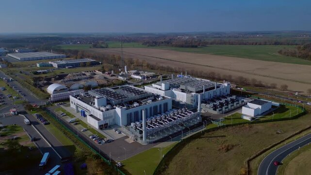 cutting edge technology and futuristic Ai infrastructure of a large-scale data center campus in Germany processing global information. Dramatic aerial view flight fly reverse drone