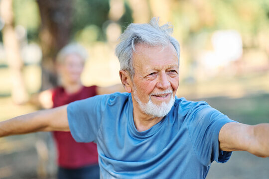 Portrait os a happy beautiful elderly senior mature couple exercising and stretching outdoors