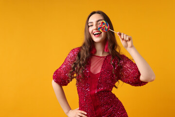 Beautiful woman with lollipop on orange background, space for text