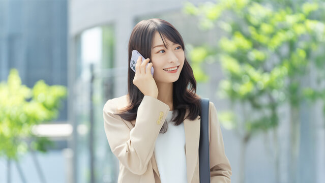 スマートフォンで話す笑顔の女性・ビジネスウーマン