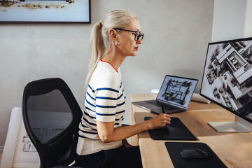 Professional female architect working on a computer with architectural designs