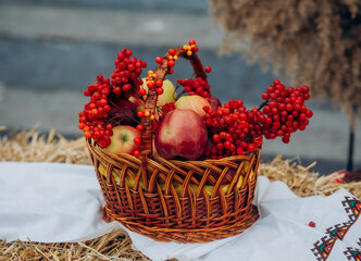 Wicker basket with viburnum and apples on Ukrainian rushnyk