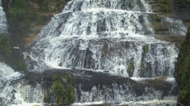 Layered waterfall terraces with moss and rocks flowing downstream in Ultra slow motion captured with a high-speed camera