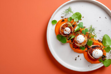 Savor exquisite pan seared scallops artfully presented atop vibrant carrot puree with delicate herb garnish, a culinary masterpiece for discerning palates and elegant dining experiences.