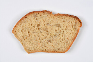 A single, irregular slice of homemade artisan bread with an airy, porous texture and crust visible on two edges, isolated on a white background
