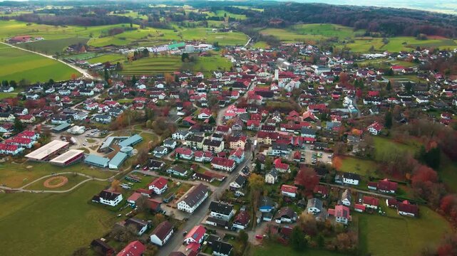 Aerial view of Andechs presenting a tapestry of red-roofed houses, lush green fields, and a central church spire, Andechs, Bayern, Germany.