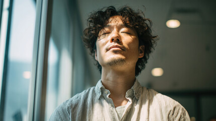 Man enjoying peaceful sunlight with eyes closed