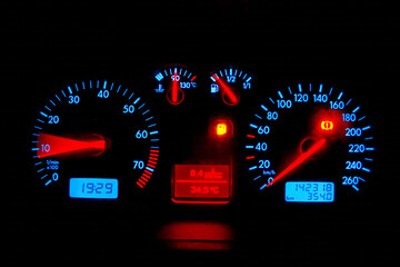 car dashboard illuminated odometer and measurement and warning indicators, isolated on black background