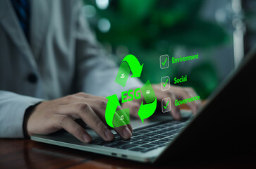 Businessman working on laptop with ESG environmental, social, and governance icons, representing sustainability, green business strategy, corporate responsibility, and eco-friendly decision-making.