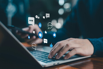 Person using laptop and smartphone with floating social media chat icons, representing online communication, engagement, messaging, and modern digital interaction across platforms.