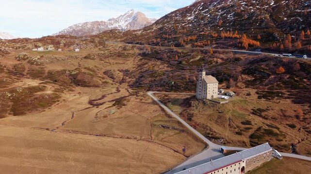 Aerial view of Simplon Hospice at Simplonpass reveals a stark landscape under a clear sky, with the iconic building standing prominently, Simplon Hospice, Wallis, Switzerland.