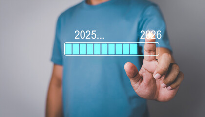 Hand touching on download bar status to change from 2025 to 2026 for countdown of merry Christmas and happy new year by technology concept 