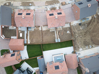 Drone top down view of a mixture of both affordable semi detached new homes and larger, detached family homes on a UK housing development project.