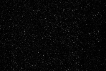 Realistic heavy snow falling slowly at night on a dark black background, abstract winter weather...