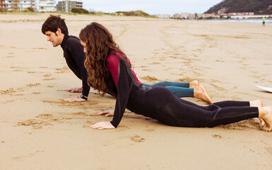 Surfer friends warming up on the beach before surfing