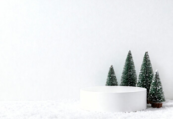 A white podium surrounded by miniature fir trees with lights. The scene is set on a snowy surface, creating a festive atmosphere for product advertising.