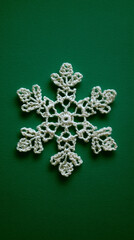 Crochet Snowflake Ornament on Green Background – Minimalist Holiday Flatlay
