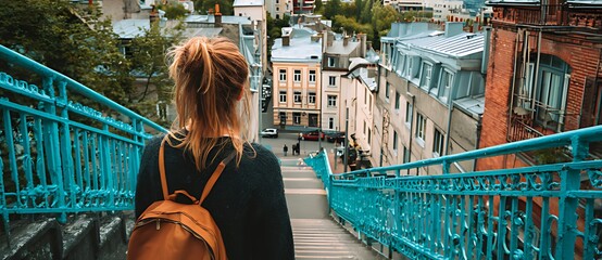 Woman overlooking a european city from a vibrant blue staircase