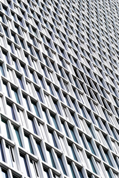 A highly patterned architectural facade where modern geometry, abstract structure, minimal detail and repeating texture build a dense grid softened by daylight within a contemporary exterior design
