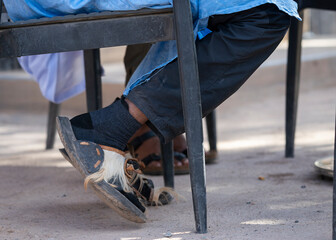 Close-up of handcrafted leather sandals with natural hair accents, capturing everyday street...