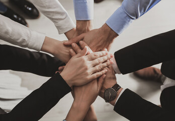 People holding hands together over light background, top view. Unity concept