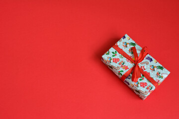 a single Gift Box with Red Ribbon on a Vibrant Red Background blank space