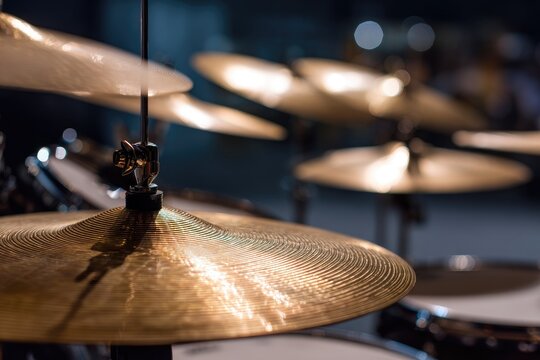 Close-up of a drum set, showcasing shiny cymbals and their support structures