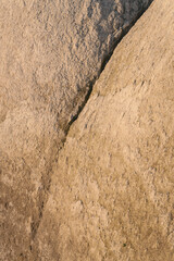 Detailed view of chalk rock with diagonal crack, rough texture, and natural erosion patterns
