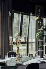 Elegant dining room with luxurious candelabra centerpiece by large windows