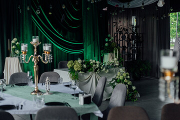 Elegant wedding reception with green velvet drapes and white floral arrangements