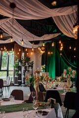 Elegant wedding reception venue with candles and green drapes