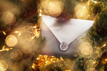 Christmas Gift Certificate Card Envelope in Christmas Bokeh Lights Tree Branches. 