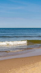 sea waves against the background of yellow sand and blue sky
