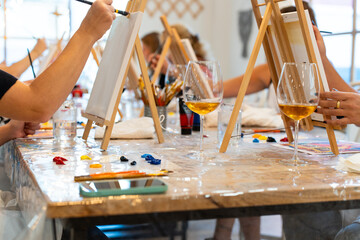 People enjoying painting, creativity, and socializing at a sip and paint workshop