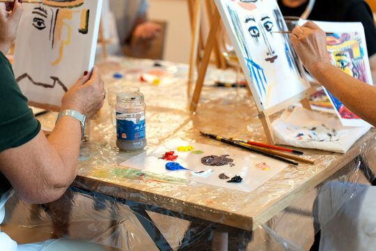 People enjoying painting art class workshop with easels - Powered by Adobe