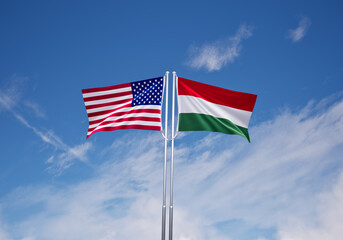 flags of hungary and United States of America over blue sky background.