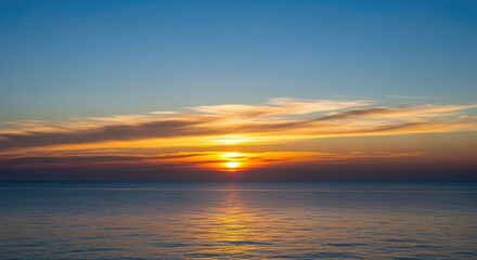 Obraz premium Sun setting on the horizon of calm peaceful ocean