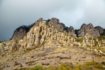 Cliffs in the Demerdzhi mountain range on a clear sunny day against a backdrop of beautiful cirrus clouds. Landscape, sights of Russia, sea, mountains.
