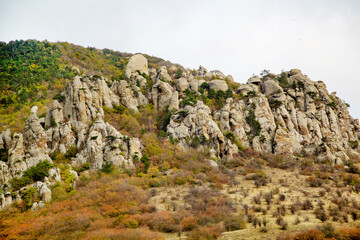 Cliffs in the Demerdzhi mountain range on a clear sunny day against a backdrop of beautiful cirrus clouds. Landscape, sights of Russia, sea, mountains.
