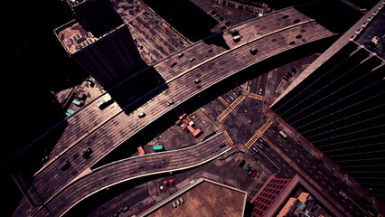 Vehicles navigate a complex network of roads in a bustling city. Tall buildings tower around the intersection, showcasing an active urban landscape under a clear blue sky.