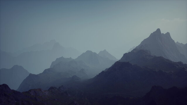 A breathtaking view of layered mountains stretches across the horizon as dusk settles in. Soft shades of blue and gray create a tranquil atmosphere, inviting reflection and wonder.