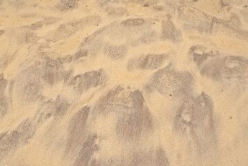  Pattern of dark and light coloured sand on the beach caused by the wind 