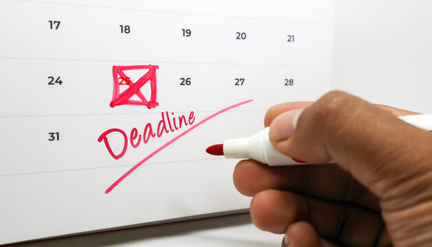 A hand marking Deadline and crossing out the 25th on a calendar with a red marker.