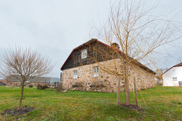 Fototapeta premium Nurme Manor Building with Antique Agricultural Tools on the Lawn